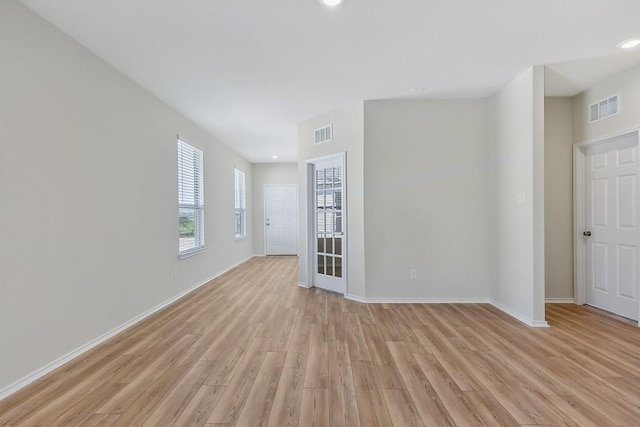 spare room featuring baseboards, visible vents, and light wood finished floors