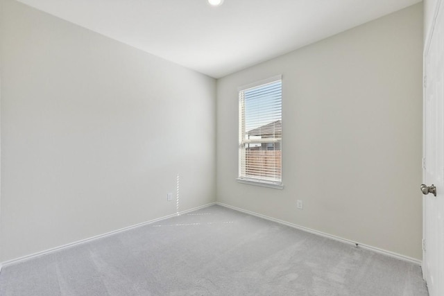 unfurnished room with carpet and baseboards