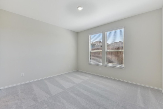 unfurnished room featuring carpet flooring and baseboards