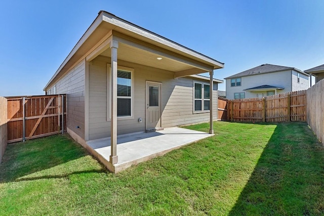 rear view of house with a lawn, a patio area, a fenced backyard, and a gate