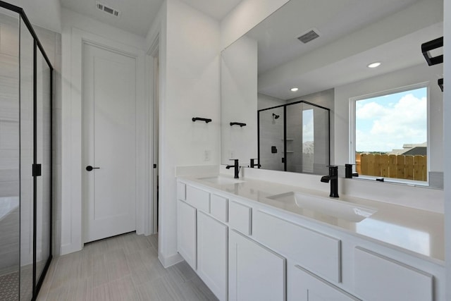 bathroom featuring vanity and a shower with shower door