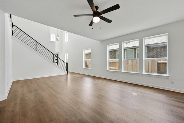 unfurnished living room featuring a healthy amount of sunlight, hardwood / wood-style floors, and ceiling fan