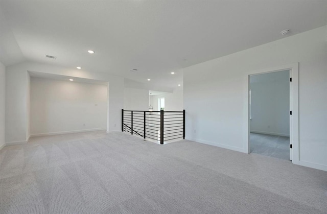 carpeted empty room featuring vaulted ceiling