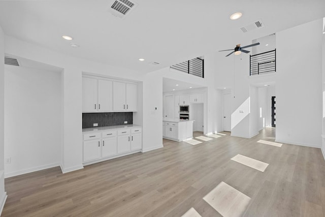 unfurnished living room with ceiling fan and light hardwood / wood-style floors