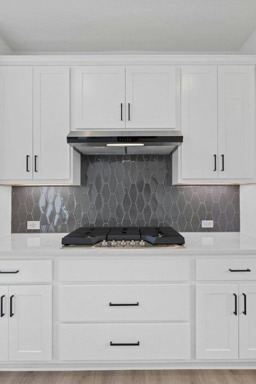 kitchen featuring range hood and white cabinetry