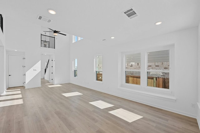 unfurnished living room featuring light wood-type flooring, a healthy amount of sunlight, ceiling fan, and basketball court