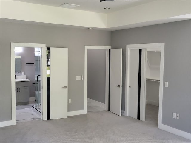 unfurnished bedroom with light colored carpet, sink, and connected bathroom