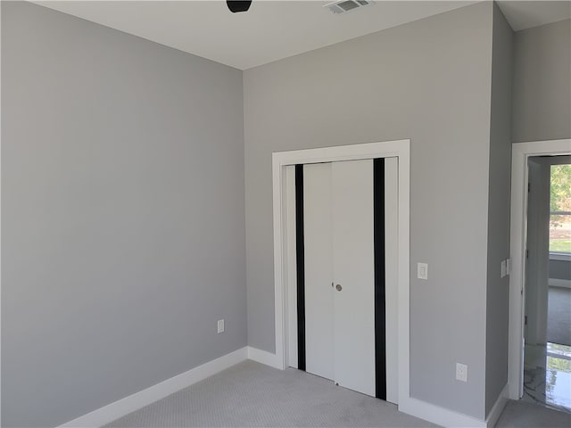 unfurnished bedroom with carpet, a closet, and ceiling fan