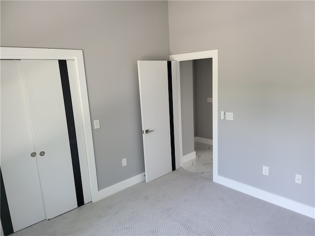 unfurnished bedroom with a towering ceiling and light colored carpet