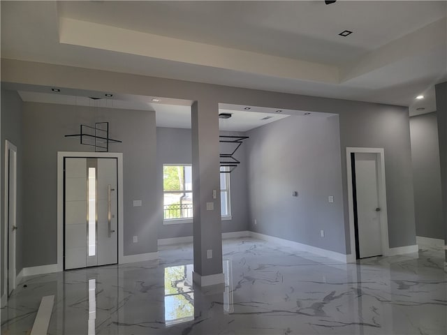 entryway featuring a tray ceiling and light tile floors