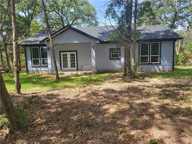 ranch-style home with french doors and a front lawn