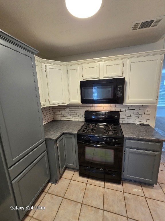 kitchen featuring black appliances, light tile patterned floors, decorative backsplash, and white cabinets