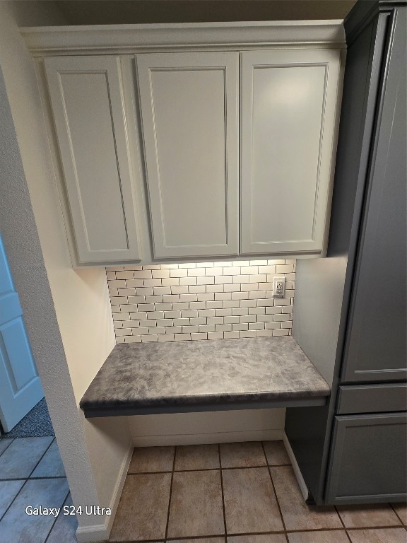 interior details with backsplash and tile patterned flooring