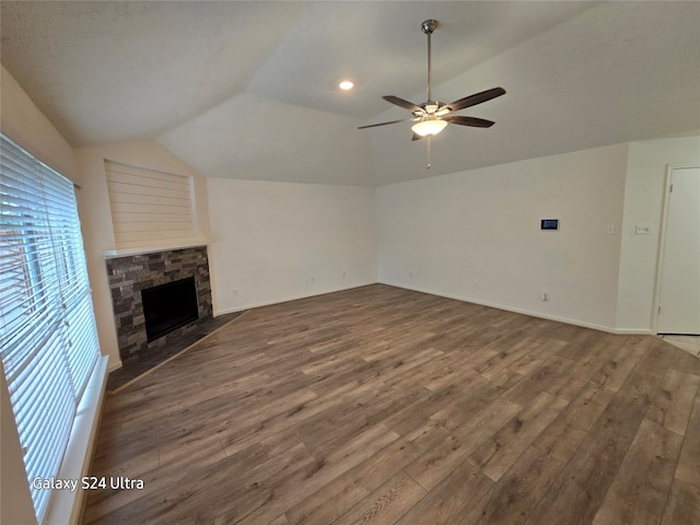 unfurnished living room with vaulted ceiling, ceiling fan, dark hardwood / wood-style flooring, and a fireplace