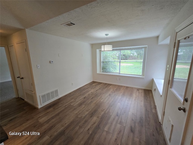 unfurnished room featuring dark hardwood / wood-style floors and a textured ceiling