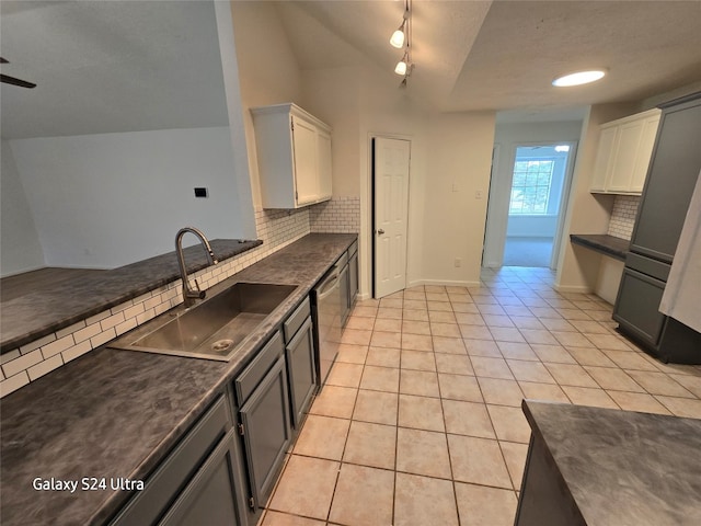 kitchen featuring light tile patterned floors, sink, decorative backsplash, white cabinetry, and track lighting