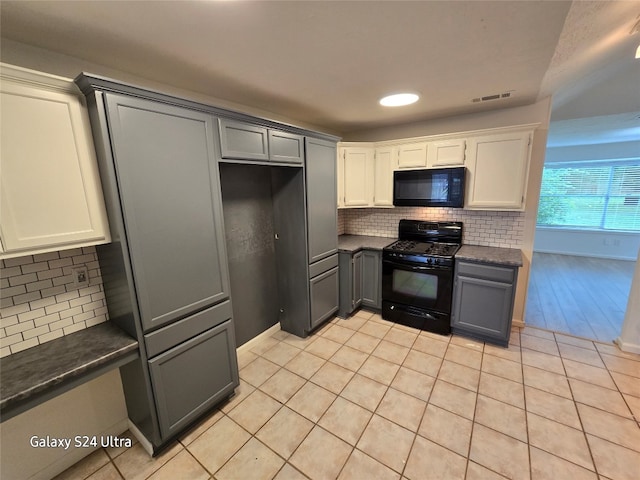 kitchen with light wood-type flooring, backsplash, black appliances, gray cabinetry, and white cabinets