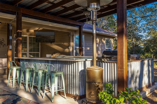 view of patio with ceiling fan, exterior bar, and grilling area