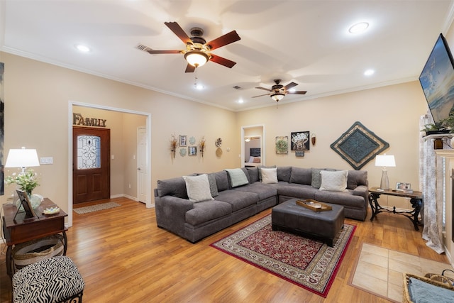 living room featuring light hardwood / wood-style floors, ornamental molding, and ceiling fan