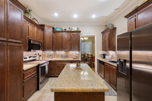 kitchen with tasteful backsplash, a kitchen island, appliances with stainless steel finishes, ornamental molding, and light stone counters