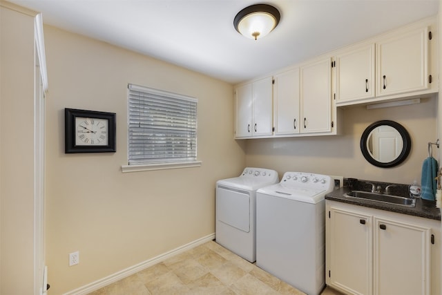 washroom with sink, washing machine and clothes dryer, and cabinets