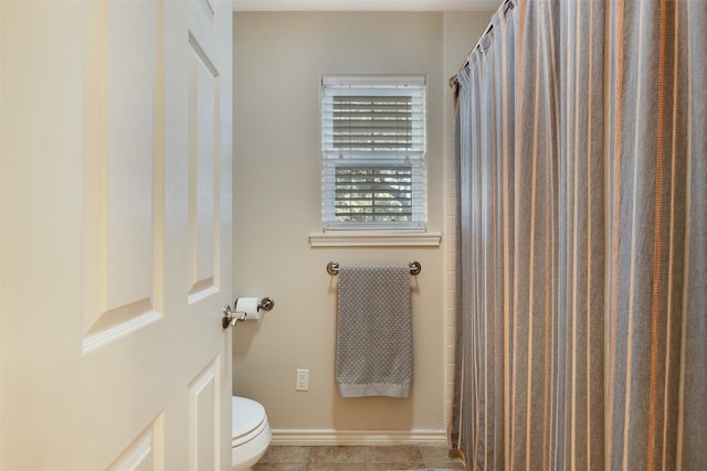 bathroom with toilet and tile patterned floors