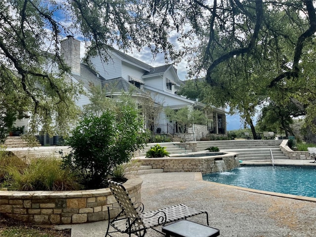 view of swimming pool featuring an in ground hot tub, a patio area, and pool water feature