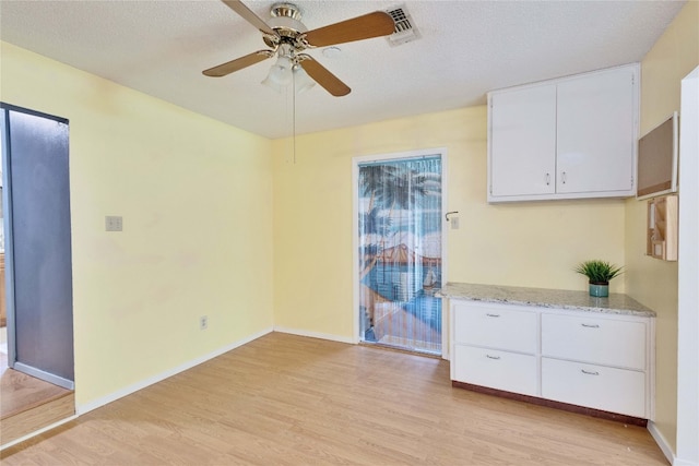 spare room featuring ceiling fan, a textured ceiling, and light wood-type flooring