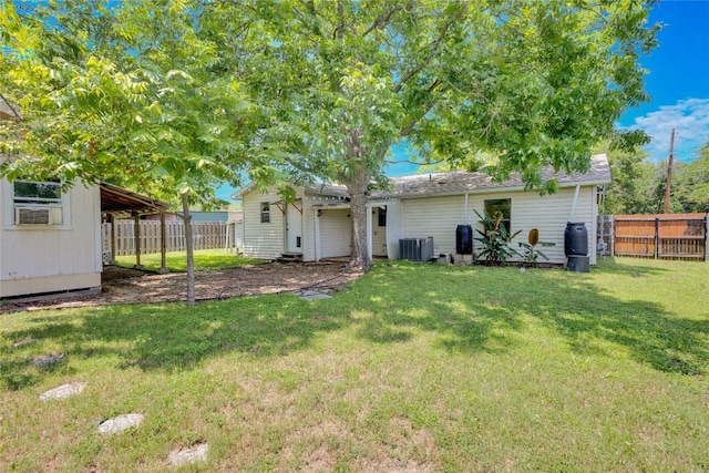 rear view of property with a lawn and central AC unit