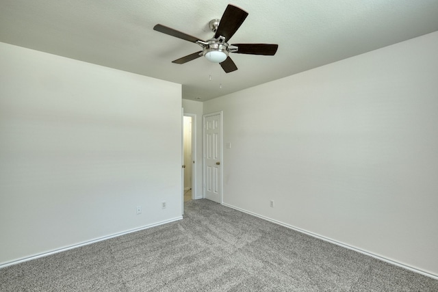 carpeted spare room featuring ceiling fan