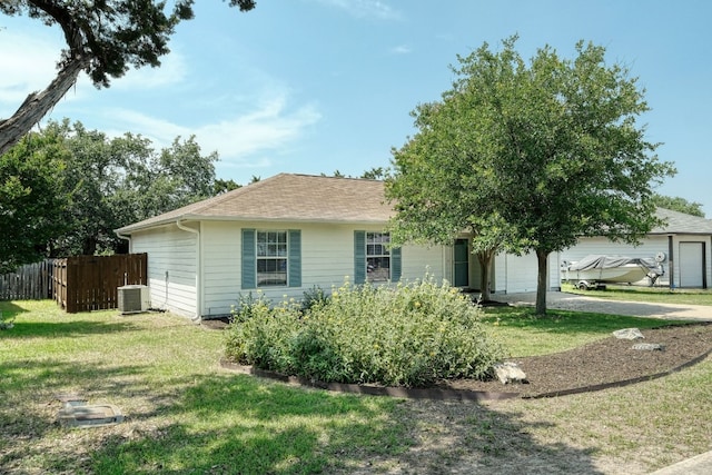 single story home featuring a garage, a front yard, and central AC unit