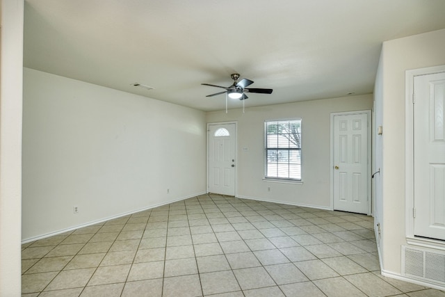 spare room with ceiling fan and light tile floors