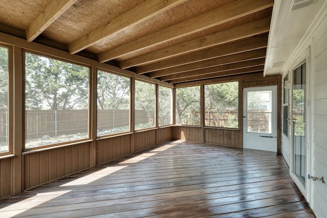 unfurnished sunroom featuring beamed ceiling and a wealth of natural light