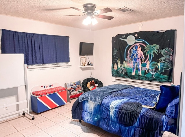 bedroom featuring tile patterned flooring, a textured ceiling, and ceiling fan