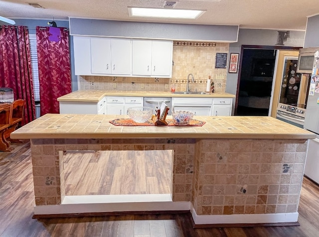 kitchen featuring white cabinetry, tasteful backsplash, dark hardwood / wood-style flooring, and sink