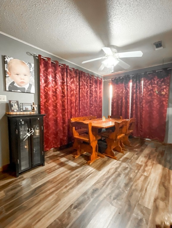 unfurnished dining area featuring hardwood / wood-style floors, a textured ceiling, and ceiling fan