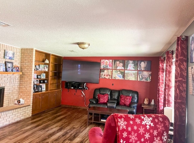 living room with hardwood / wood-style floors, a textured ceiling, and a fireplace