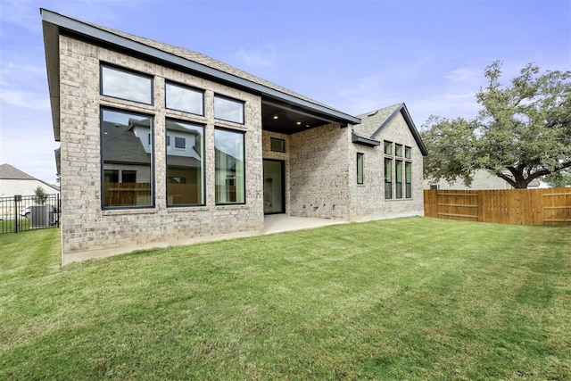 rear view of property featuring a patio, cooling unit, and a lawn