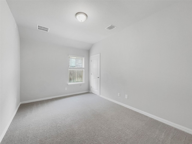 carpeted empty room with lofted ceiling