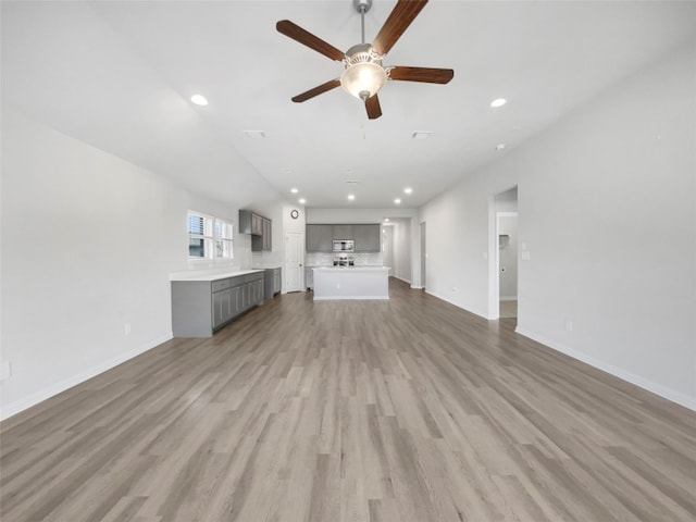 unfurnished living room featuring ceiling fan and light wood-type flooring