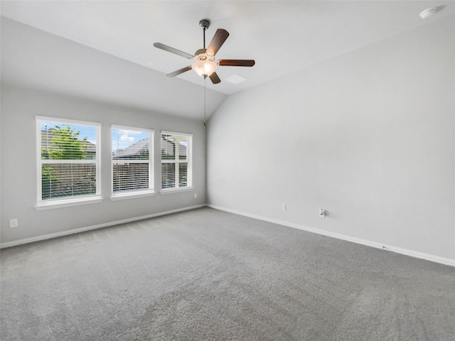 empty room with ceiling fan, lofted ceiling, and carpet flooring