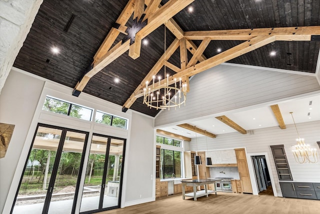 living room featuring wood-type flooring, high vaulted ceiling, and a notable chandelier