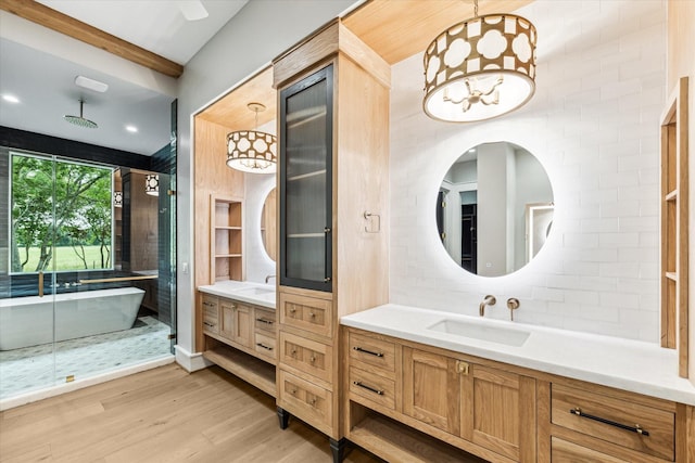 bathroom with a bathing tub, hardwood / wood-style flooring, decorative backsplash, and vanity