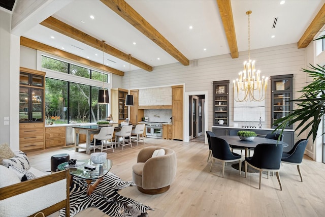 living room with an inviting chandelier, wood walls, light hardwood / wood-style flooring, and beam ceiling