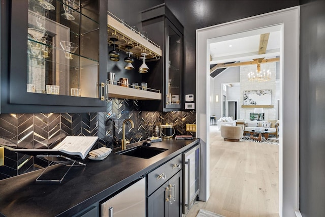 bar with sink, beamed ceiling, light wood-type flooring, backsplash, and wine cooler