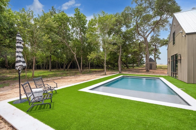 view of swimming pool with a yard