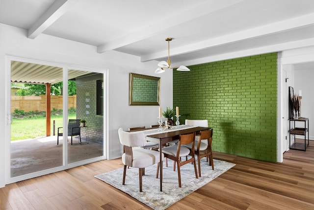 dining room with a notable chandelier, beamed ceiling, and hardwood / wood-style floors