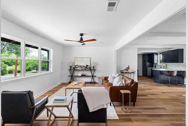 living room featuring ceiling fan and light hardwood / wood-style flooring