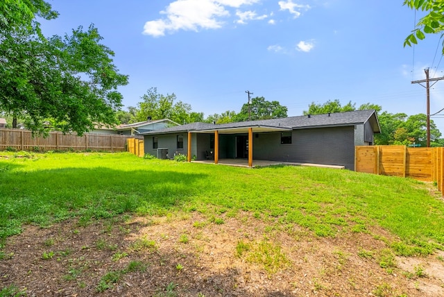 rear view of house with a patio and a yard