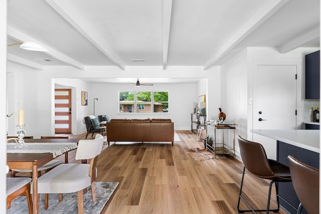 dining room featuring beamed ceiling, ceiling fan, and light hardwood / wood-style flooring